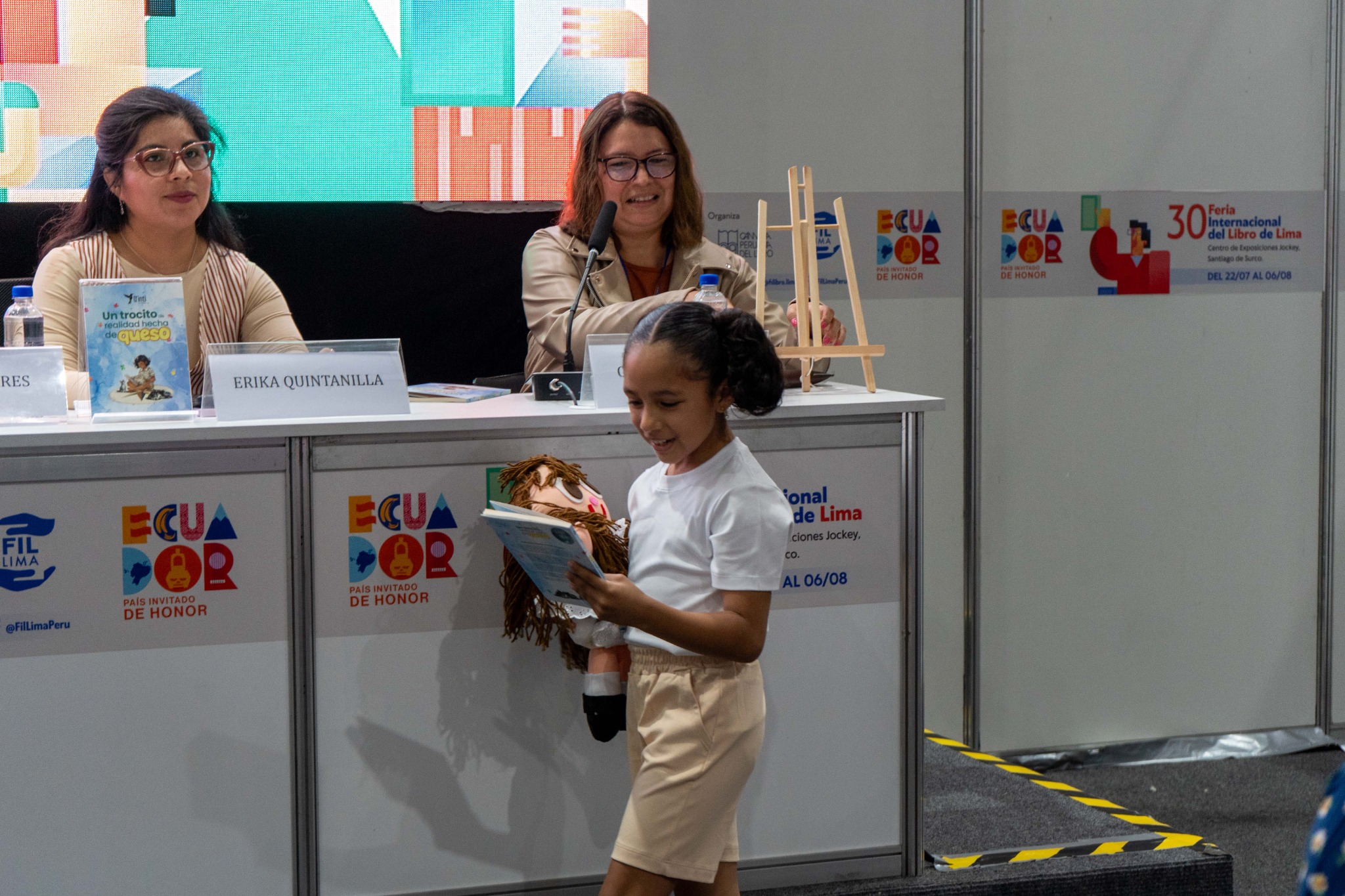 La niña protagonista entra en escena con el libro y la muñeca de trapo